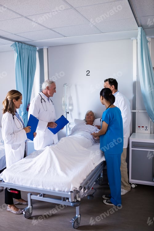 Preview: Team of doctors interacting with female senior patient