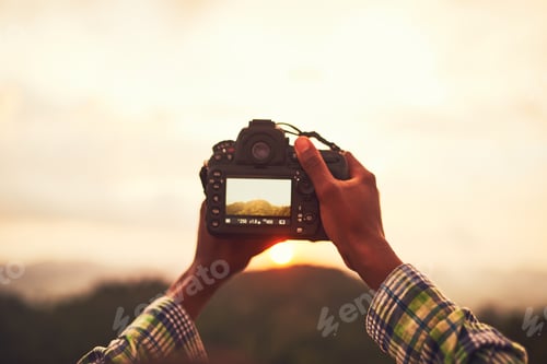 Preview: Closeup shot of an unidentifiable man taking a photo on a camera outside