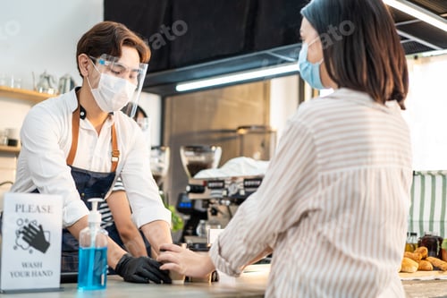 Preview: Asian Woman customer wear mask due to Covid-19 pandemic, receive drink from waiter on coffee bar