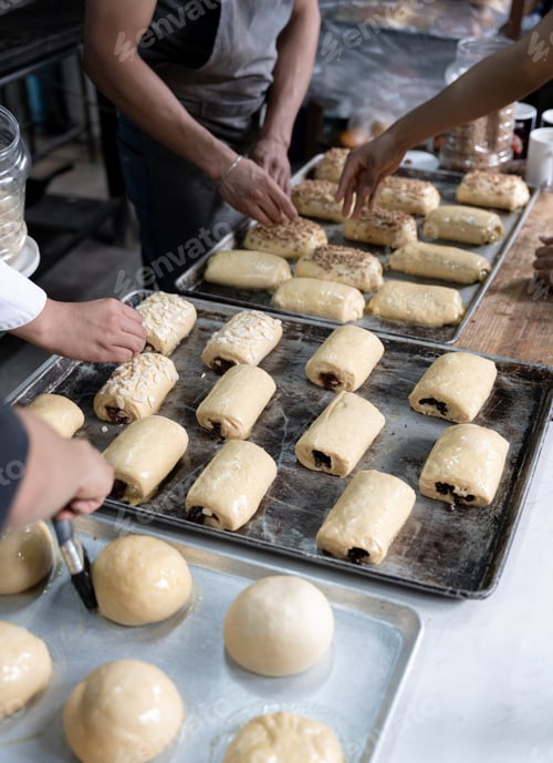 Preview: Four young Hispanic bakers are preparing different sweet buns in a bakery