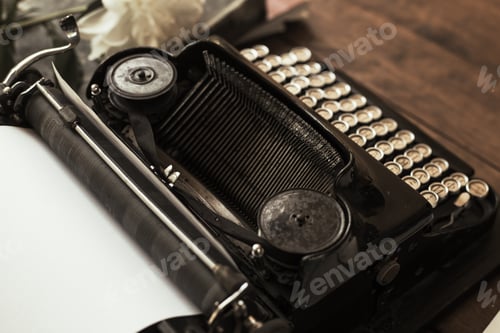 Preview: Old black typewriter with paper worth on the table