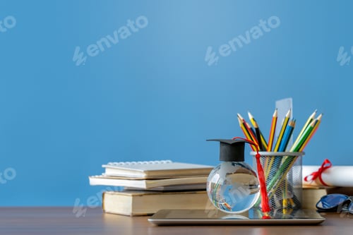 Preview: Graduation day.Education learning concept.A mortarboard on crystal globe with stack of book.