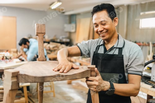 Preview: Carpenter working with wooden plank in workshop. making a furniture from wood