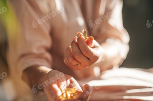 Preview: female hands hold vitamin jelly capsules pills