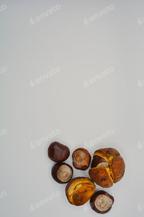 Preview: Vertical top view of shelled and unshelled chestnuts on a white surface