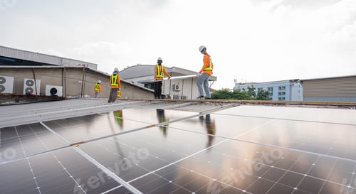Preview: n technicians carrying photovoltaic solar moduls on roof.