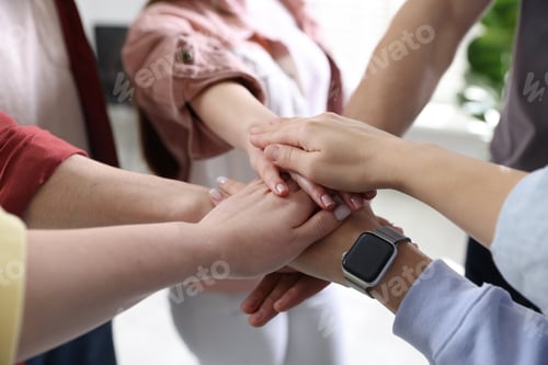 Preview: Unity concept. People holding hands together indoors, closeup