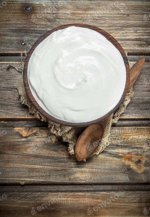 Preview: Fresh sour cream in bowl with spoon .