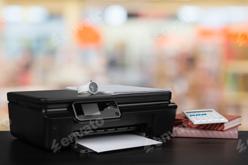 Preview: Stack of books and home printer against blurred background
