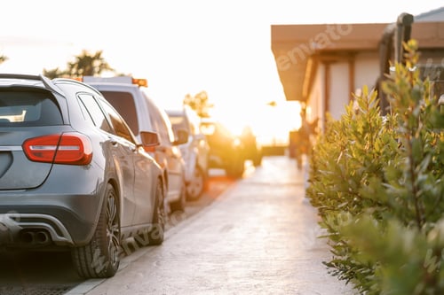 Preview: Row of cars parked near the sunny sidewalk in front of the house