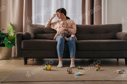Preview: Young tired woman suffering from postnatal depression at home