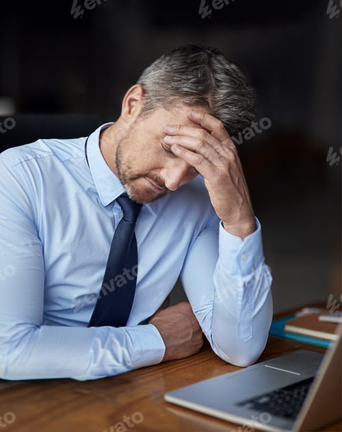 Preview: Cropped shot of a mature businessman looking anxious while working in his office