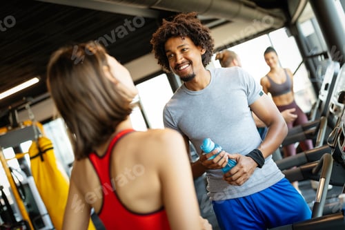 Preview: Happy friends enjoying break while chatting in the gym