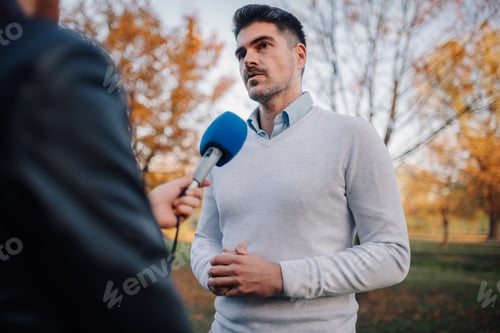 Preview: Journalist interviewing politician in park during autumn