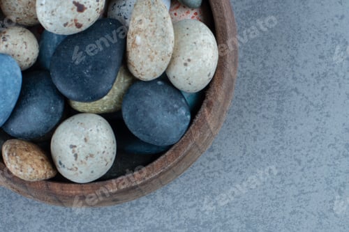 Preview: Pebble stone candies in a bowl, on the marble background
