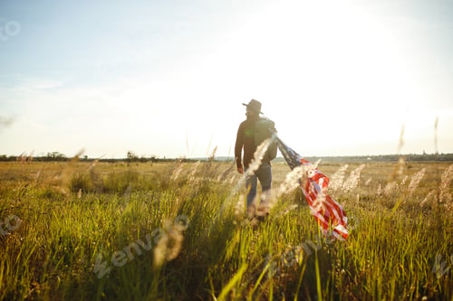 Preview: 4th of July. American Flag. Traveler with the flag of America. The man in a hat, a backpack.