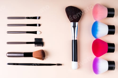 Preview: Cosmetics accessories for makeup on beige background flat lay. Set of cosmetics brushes