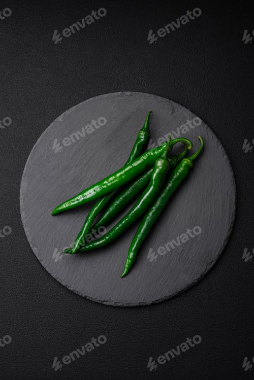 Preview: Fresh hot green chili peppers on a dark concrete background