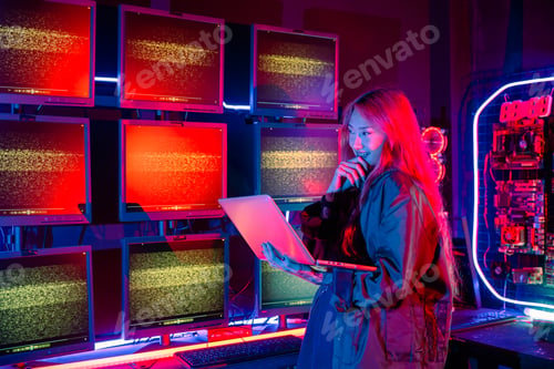 Preview: Asian woman holding laptop computer with CCTV room she check maintain security in monitor display