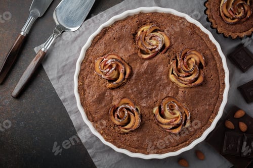 Preview: Homemade chocolate cake with frangipane and apple blossoms on a dark concrete or stone background of