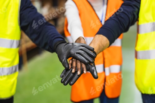 Preview: Construction workers stacking hands showing teamwork and unity