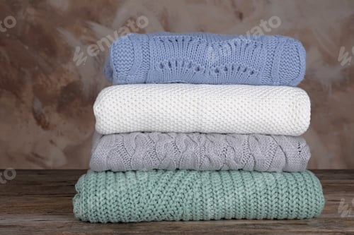 Preview: Stack of Folded Knitted Sweaters in Pastel Colors