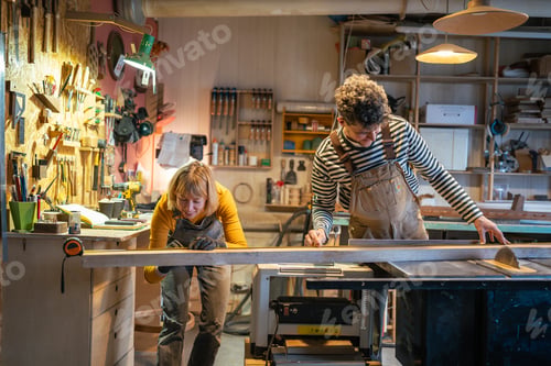 Preview: Carpentry colleagues handle circular saw station, measure wood beam with precision. Family business