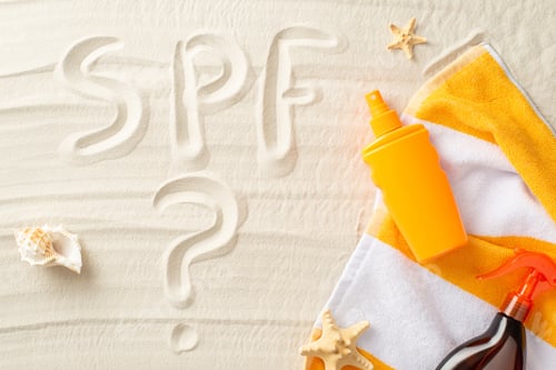 Preview: Ultraviolet Safety Month concept. Above view photo of SPF sign written on the sand