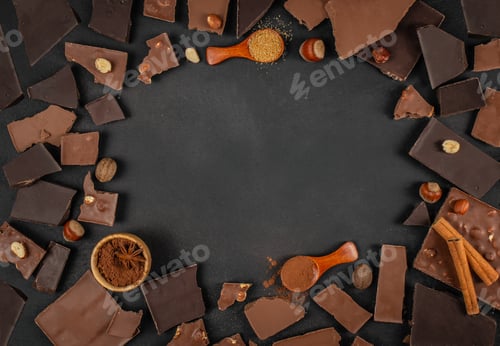 Preview: Chocolate pieces, nuts, cocoa powder and spices arranged around empty dark background