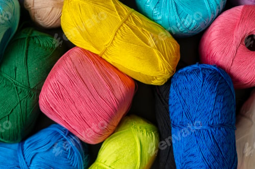 Preview: a close up dark shadow background made of collection of colorful yarn rolls of natural material