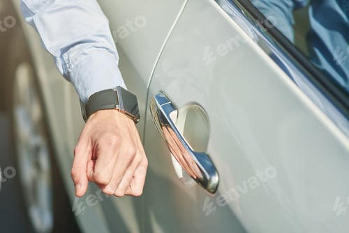 Preview: Close up shot of a male hand with smartwatch, man going to open the car while standing outdoors