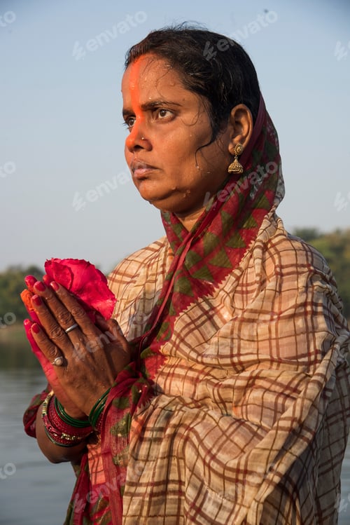 Preview: Traditionally dressed Indian woman pray into the river on Chhat Puja Festival.
