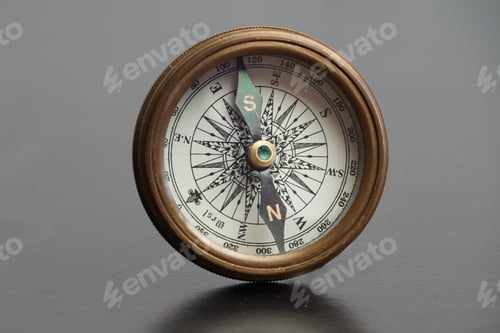 Preview: Vintage brass compass on a gray background.