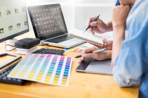 Preview: graphic designer team working on web design using color swatches editing artwork using tablet and a