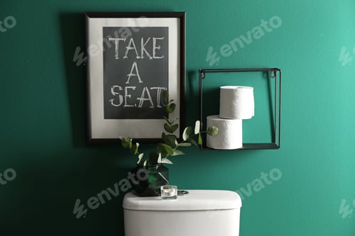 Preview: Decor elements, paper rolls and toilet bowl near green wall. Bathroom interior