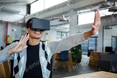Preview: Smiling businesswoman using virtual reality headset