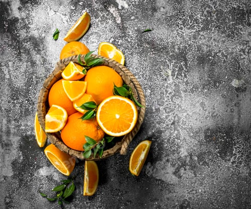 Preview: Fresh oranges in a wooden bucket.