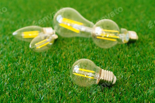 Preview: Five light bulbs on grass close up