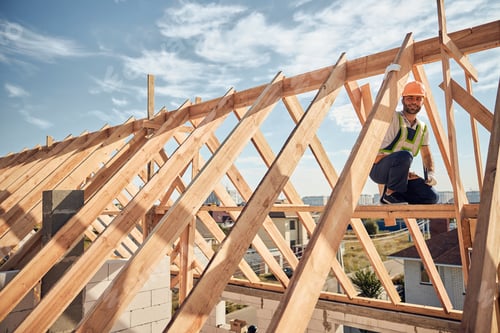 Preview: Careful contractor working with a hammer high on the building