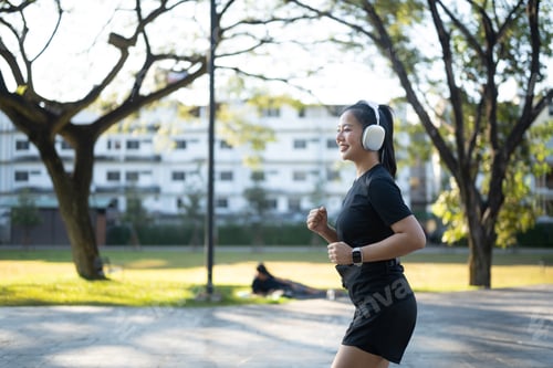 Preview: woman running and wearing headphone in the park