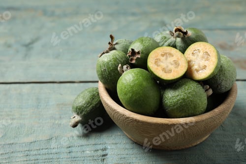 Preview: Fresh green feijoa fruits on blue wooden table, closeup. Space for text
