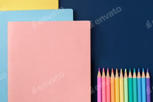 Preview: top view pastel notebook with pencil and stationery on navy blue table background