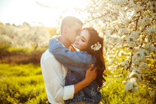 Preview: Beautiful loving couple in blooming gardens. Wedding concept. Great sunset light. Lovely newlyweds.