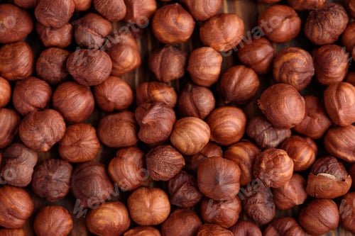 Preview: Close-up of roasted hazelnuts on a wooden surface. Top view