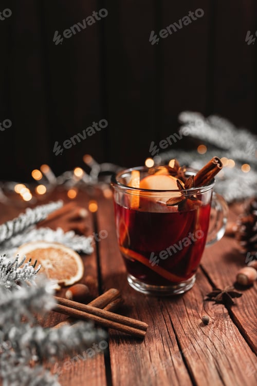 Preview: Glass cup of Mulled Wine on wooden table and background. Christmas time concept