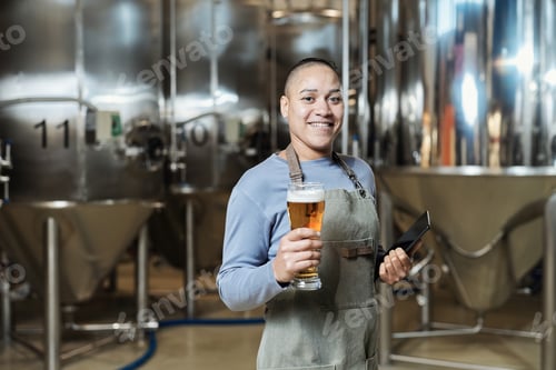 Preview: Female brewmaster holding beer glass
