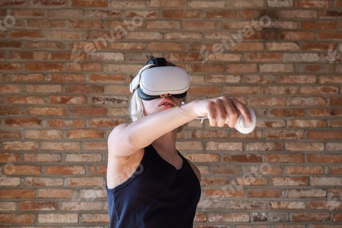 Preview: Teenager using virtual reality headset with controller. Boy playing vr game at home.