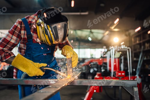 Preview: Man welding metal with welding machine while wearing a protective gear