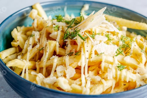 Preview: Bowl of french fries topped with sauce