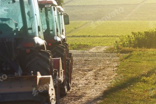 Preview: row of agriculture tractors in front of vineyard